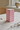 Pink vase fra klevering, centreret på cremefarvet hørdug